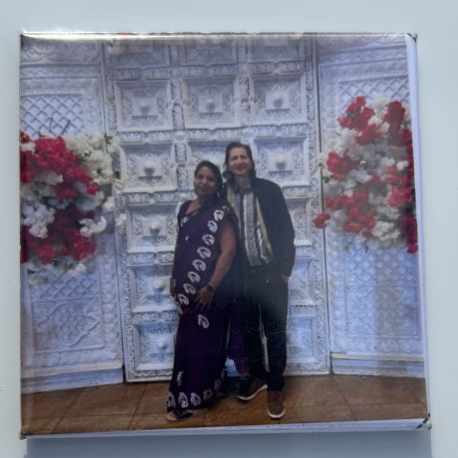 Photo magnet of guests in front of a floral event backdrop
